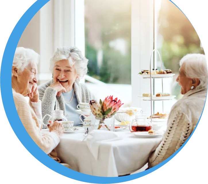 Eine Gruppe von Seniorinnen genießt gemeinsam Kaffee und Kuchen in einer hellen, freundlichen Atmosphäre.