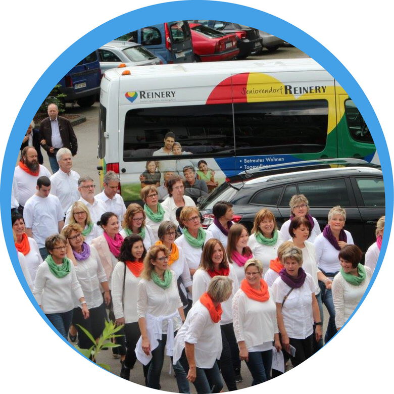 Das große Team der Reinery Pflege vor einem der Firmenbusse; Zusammenhalt und Vielfalt in der Mitarbeiterschaft.