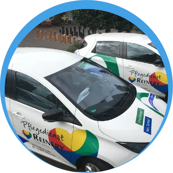 Die Fahrzeugflotte des Reinery Pflegedienstes; weiße Autos mit dem bunten Herz-Logo sorgen für Mobilität in der ambulanten Pflege.